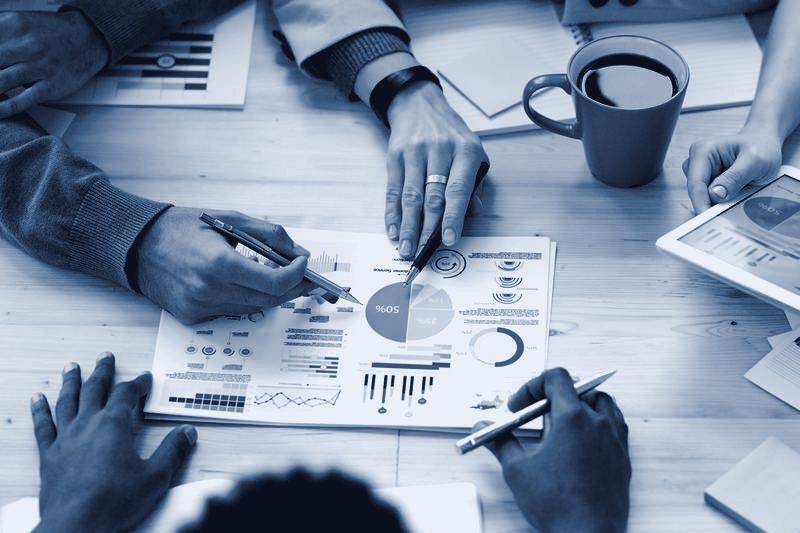 Mesa com relatórios e gráficos durante análise de indicadores
